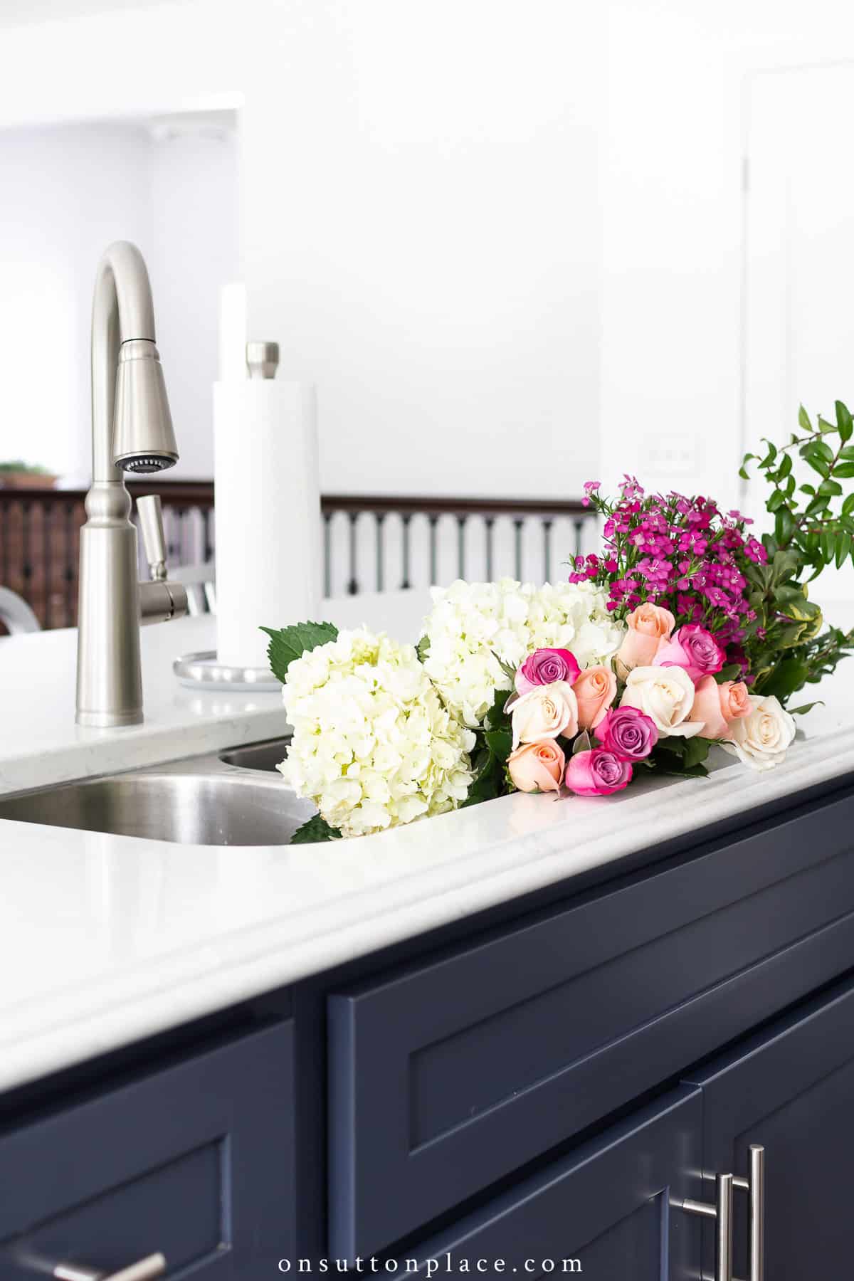 cuisine bleu et blanc avec des fleurs dans l'évier